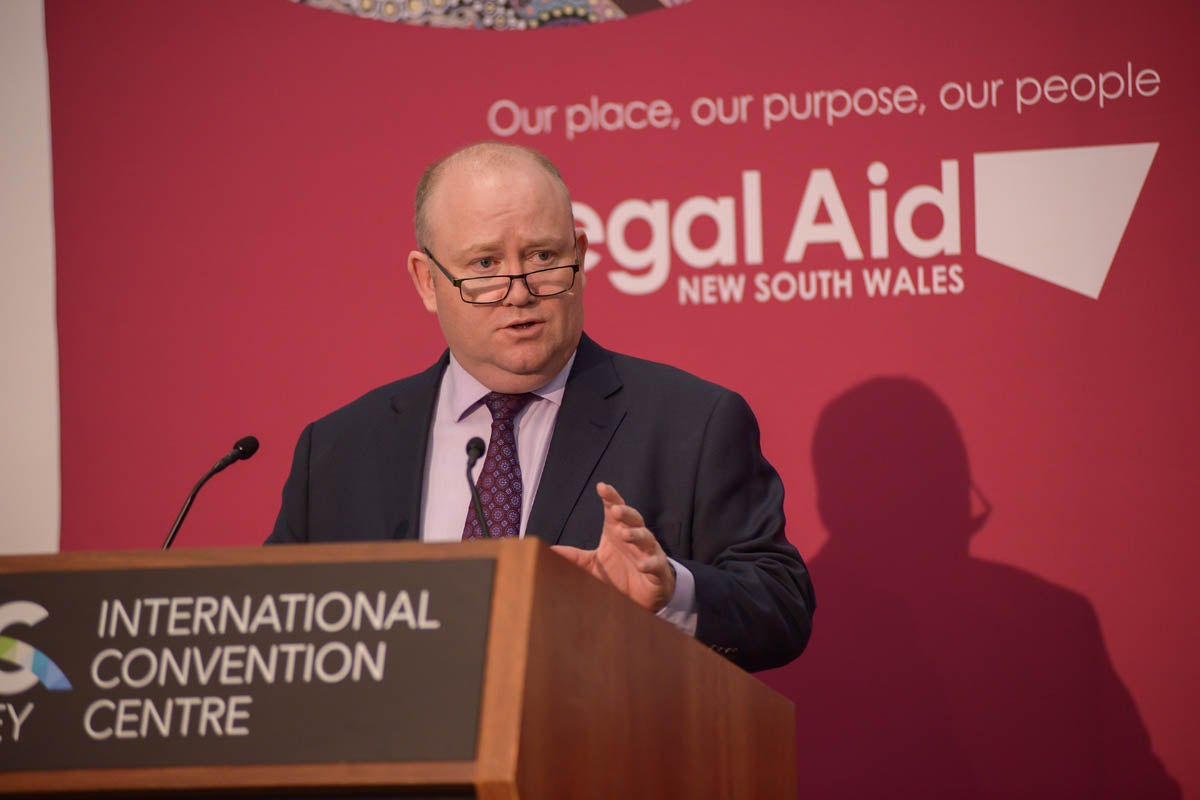 Shane Fitzsimmons stands behind a lectern, mid-speech.